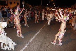 Más de veinte carrozas, quince grupos de baile y música y cientos de mascaritas animan a la multitud de vecinos y turistas reunida a lo largo del recorrido.