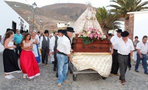 El pueblo gozoso participa de la procesión y confraterniza animado por música tradicional canaria. 